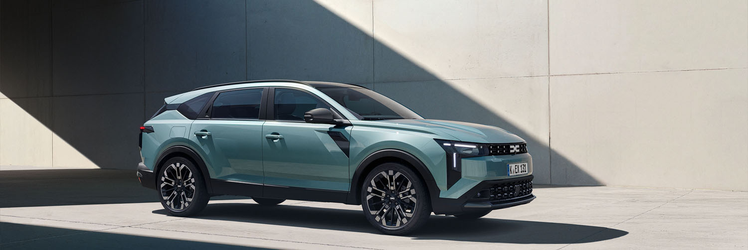 Der neue Dacia Striker. Jetzt entdecken und nichts verpassen. Ein türkisener Dacia Striker, ein neues Modell von Dacia parkt unter einer Brücke in einer modernen Stadt.